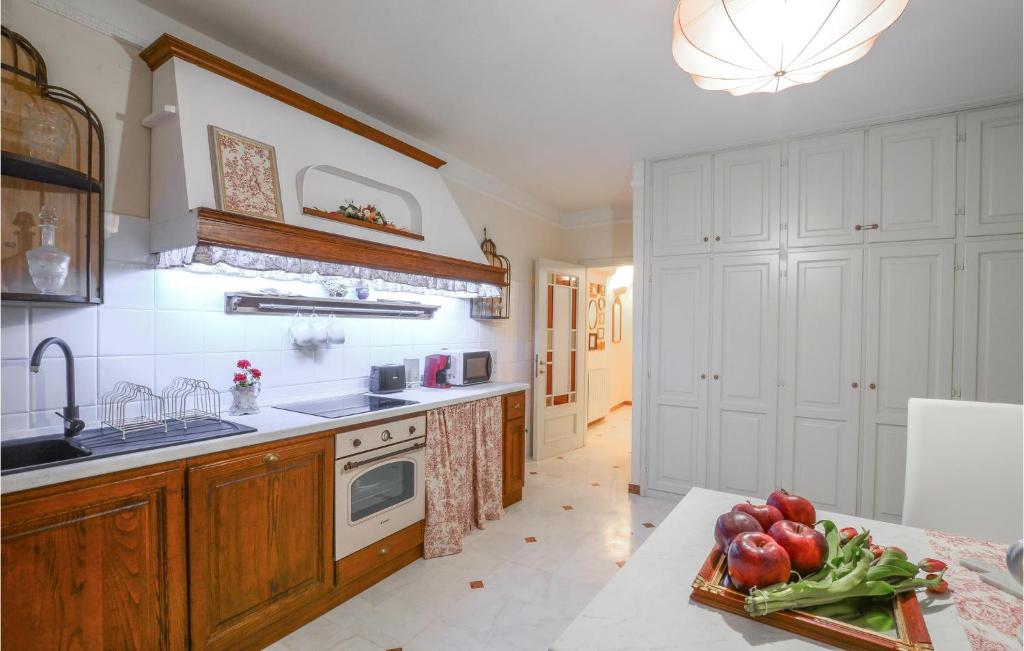 una cocina con armarios blancos y una mesa con frutas y verduras en Nice Apartment In Bagnone With Kitchen en Bagnone