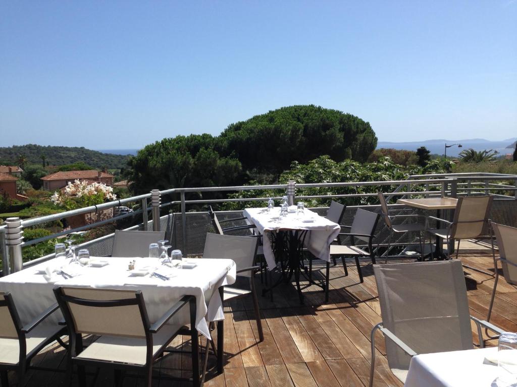 un restaurante con mesas y sillas en un balcón en Hotel La Cigale, en La Croix-Valmer