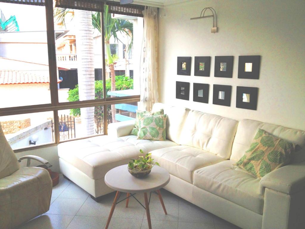 a living room with a white couch and a table at Apartment Bello Horizonte in Santa Marta