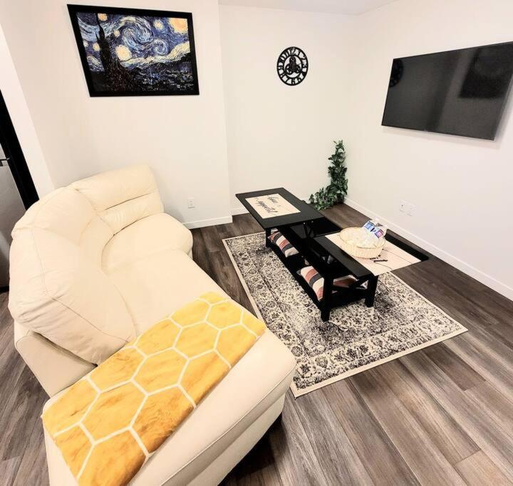 a living room with a white couch and a table at Somy Suite - Cozy 2bedrom with two queens bed and free street parking in Calgary