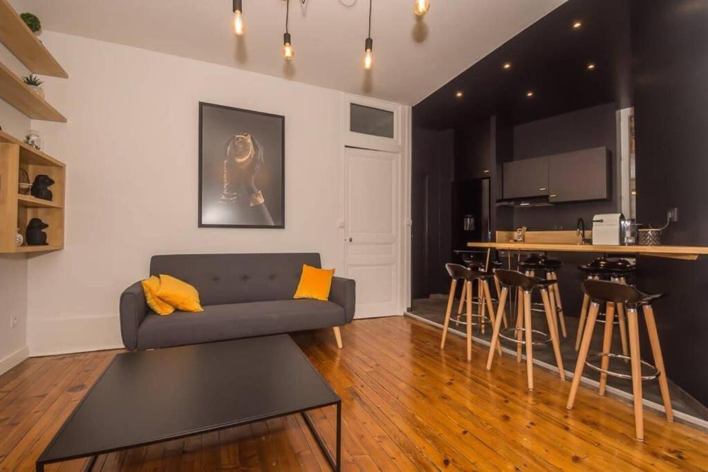 a living room with a couch and a kitchen at T3quartier Rsidentielcosyfamilleamis in Mâcon