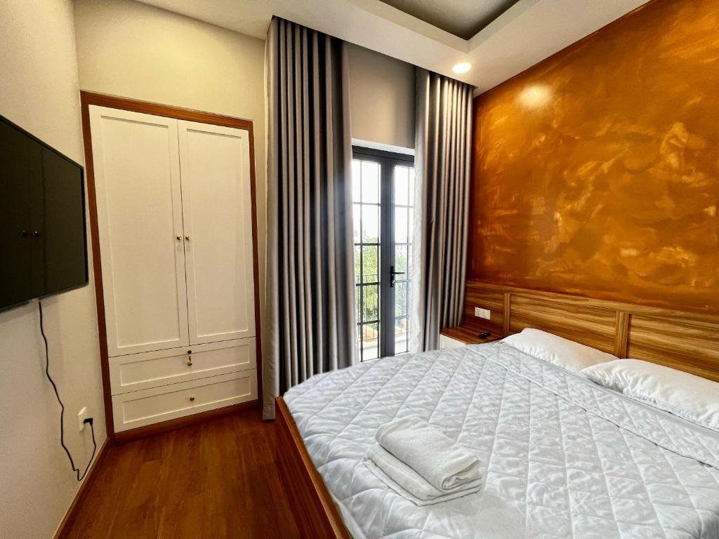 a bedroom with a bed and a large window at Duy Quan Villa NovaWorld Phan Thiet 04 in Bình Tú