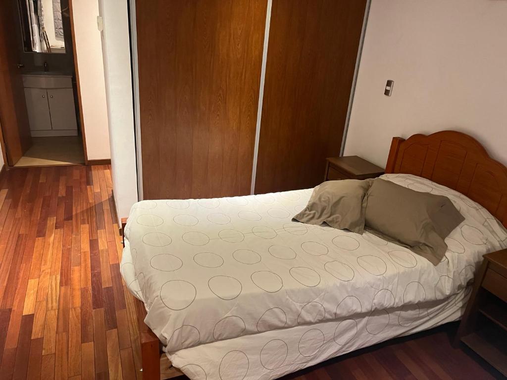 a bedroom with a bed and a wooden floor at Jessica in Santiago