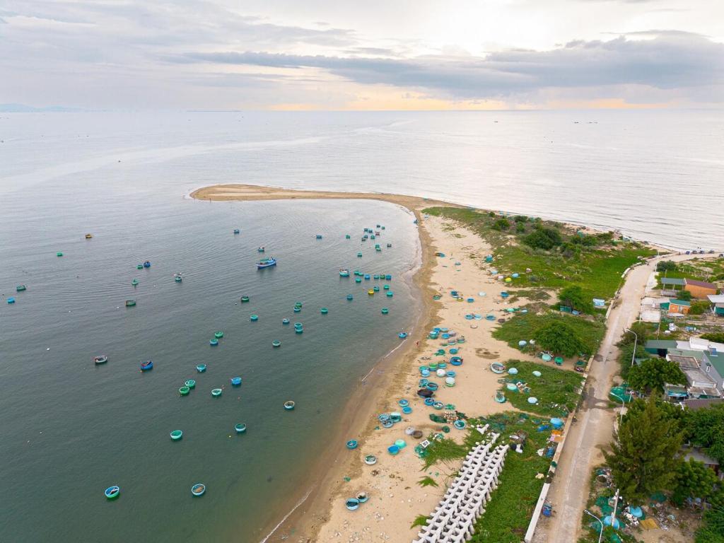 an aerial view of a beach with umbrellas and boats at Ruhigen Legend Villa Vesta Collections in Phan Rang