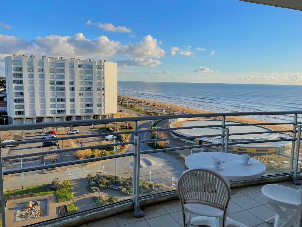- un balcon avec une table et des chaises et la plage dans l'établissement Studio avec balcon, plage à 50m, WIFI, animaux acceptés - FR-1-323-418, à Saint-Jean-de-Monts