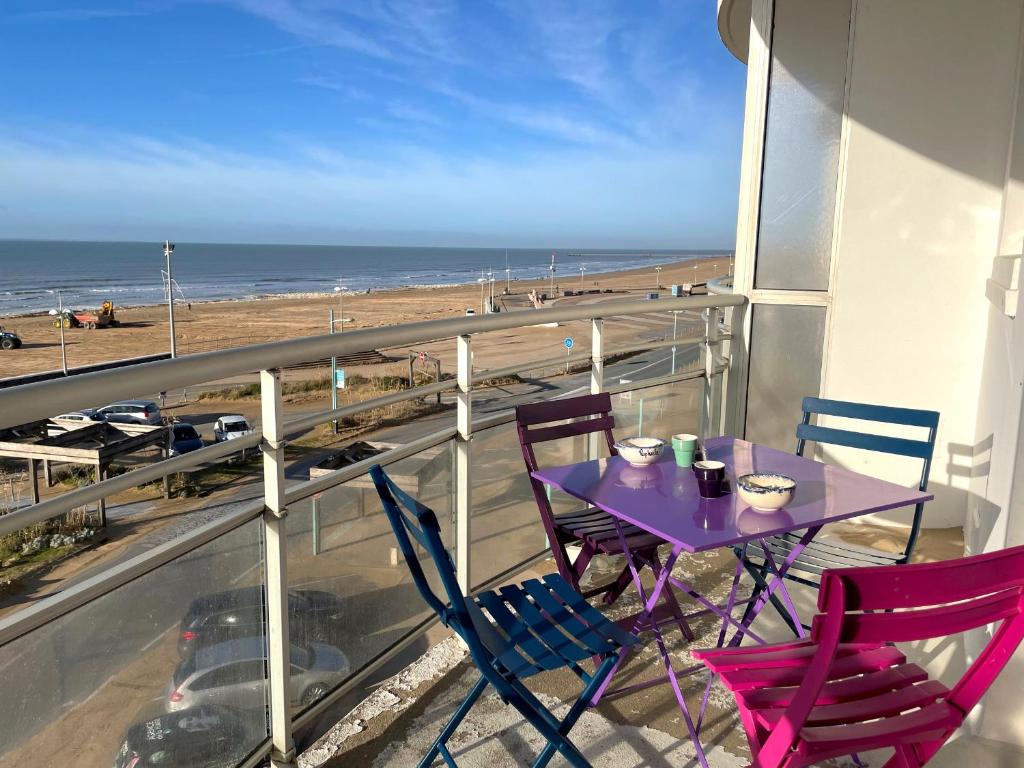 une table et des chaises sur un balcon avec vue sur la plage dans l'établissement Studio moderne face mer avec grand balcon à Saint-Jean-de-Monts, classé 1* - FR-1-323-431, à Saint-Jean-de-Monts