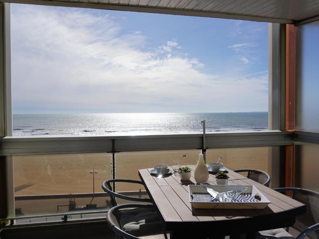 - une table avec vue sur l'océan depuis une fenêtre dans l'établissement Beau studio 4 pers avec balcon et parking face à la mer - FR-1-323-427, à Saint-Jean-de-Monts