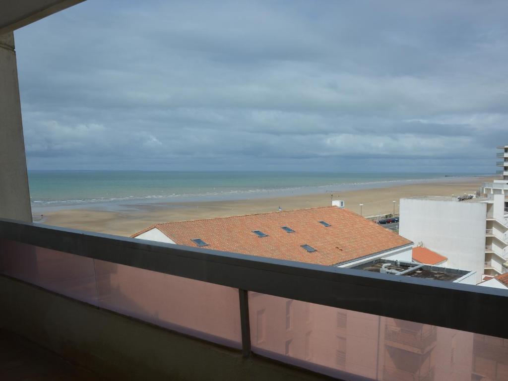 une vue sur la plage depuis le balcon d'un immeuble dans l'établissement Appartement cosy à 50m de la plage pour 4 pers. avec balcon à Saint Hilaire de Riez - FR-1-323-448, à Saint-Hilaire-de-Riez