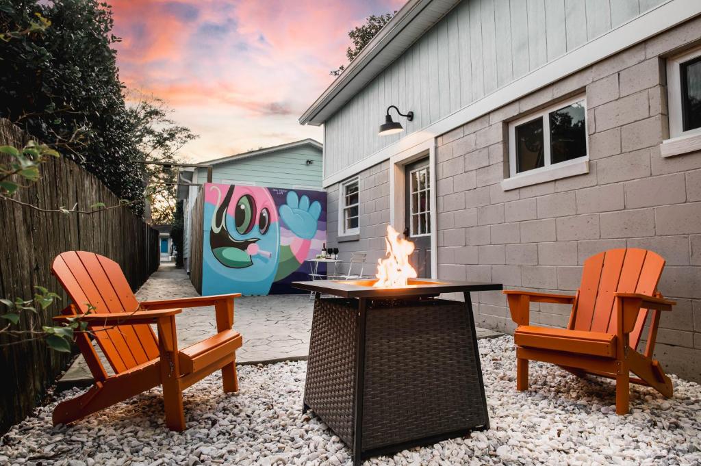 a patio with two chairs and a table with a fire at Olde Village Loft - Unique Park Circle Experience in Charleston