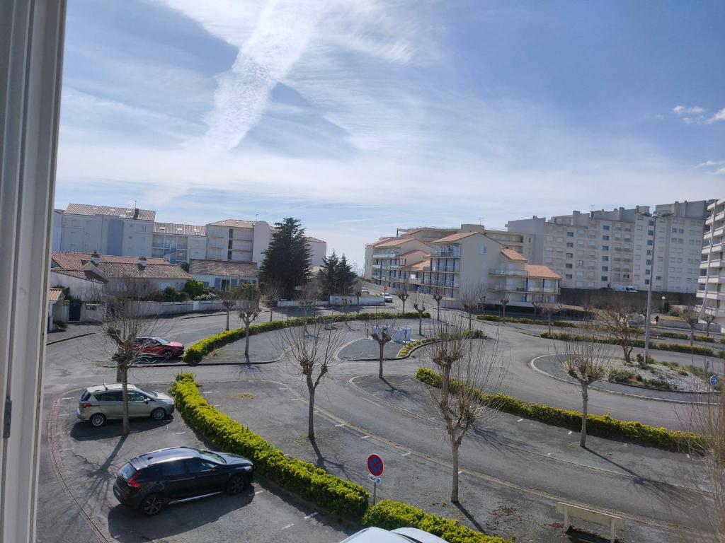 - une vue depuis la fenêtre d'un parking avec des voitures dans l'établissement Appartement rénové 4 pers, 200m plage, proche commerces, balcon, parking, animaux admis - FR-1-323-443, à Saint-Hilaire-de-Riez