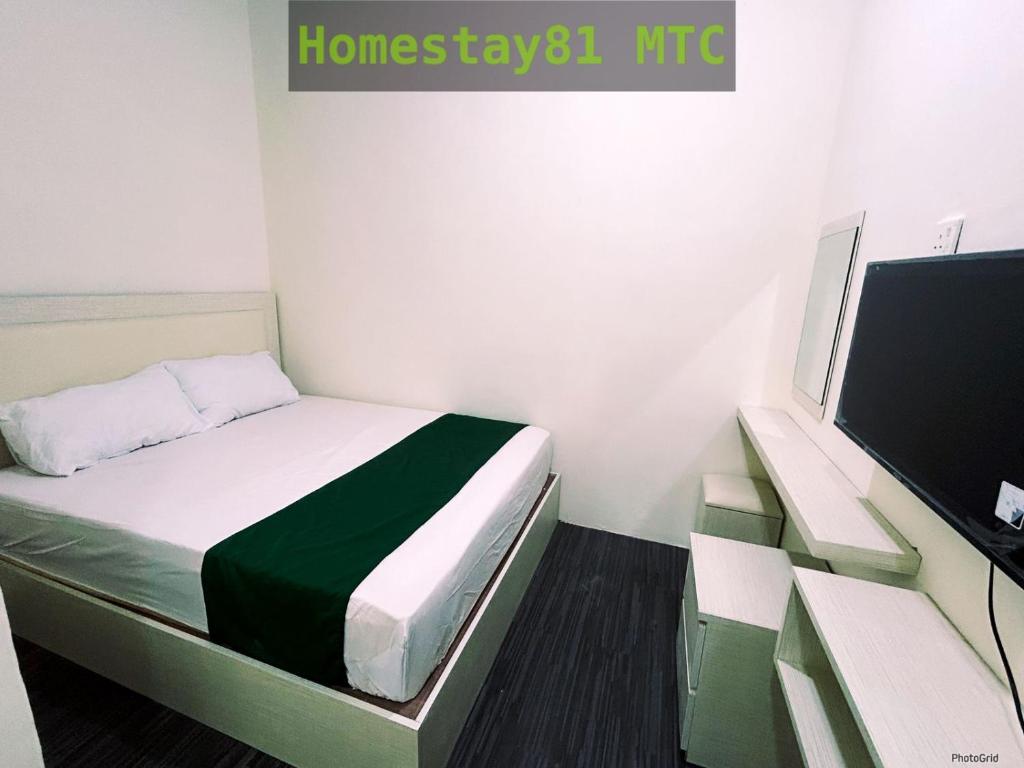 Habitación pequeña con cama y TV. en Homestay81 MTC en Nongsa