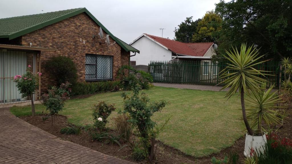 a brick house with a yard with a yard sidx sidx sidx at The garden house in Boksburg