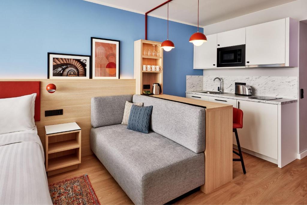 a living room with a couch and a kitchen at Residence Inn by Marriott Munich Central in Munich