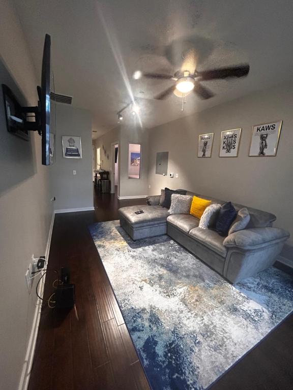 a living room with a couch and a ceiling fan at On The Go Stays in Dallas