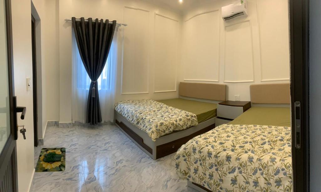 um quarto com 2 camas e uma janela em Rustic Homestay - Phòng nghỉ giá rẻ em Hai Phong