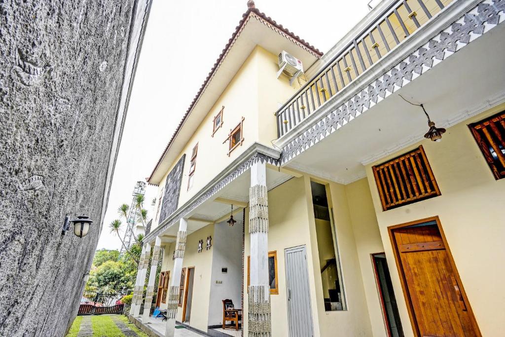 un bâtiment blanc avec un escalier latéral dans l'établissement OYO Life 92030 Ef Palm Guest House Family, à Surabaya