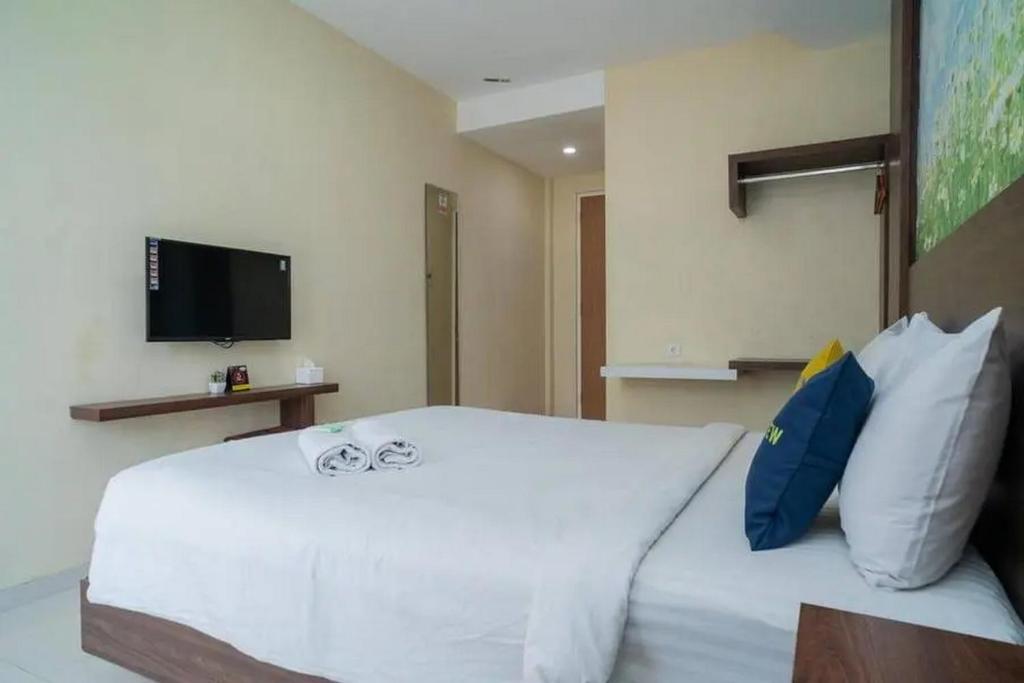 Postel nebo postele na pokoji v ubytování Urbanview Hotel Omah Anin Batu by RedDoorz