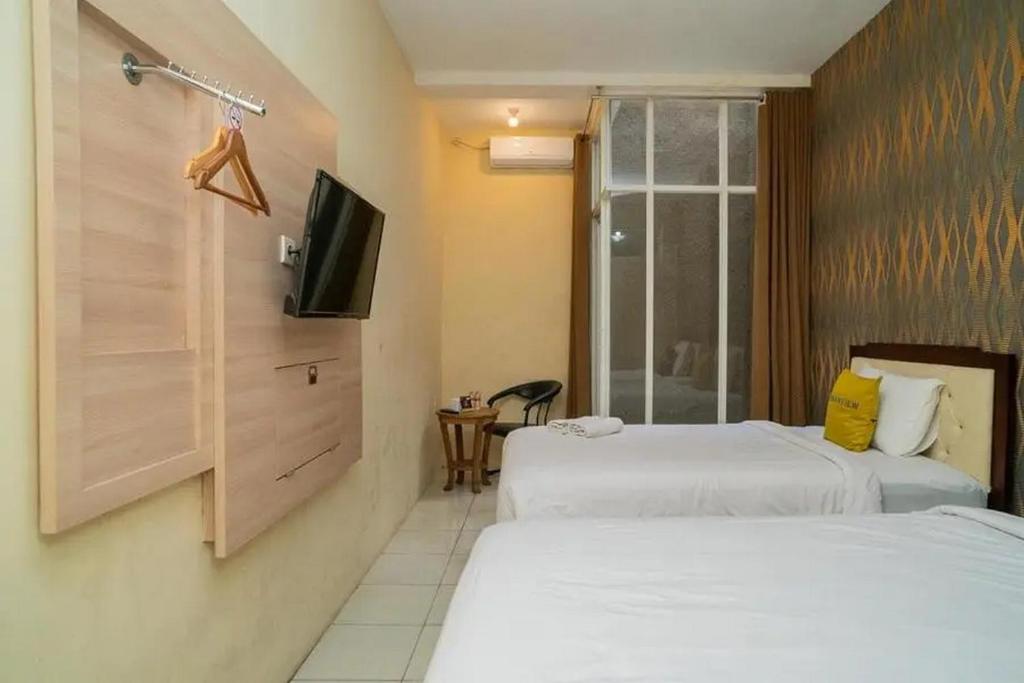 Postel nebo postele na pokoji v ubytování Urbanview Hotel Omah Anin Batu by RedDoorz