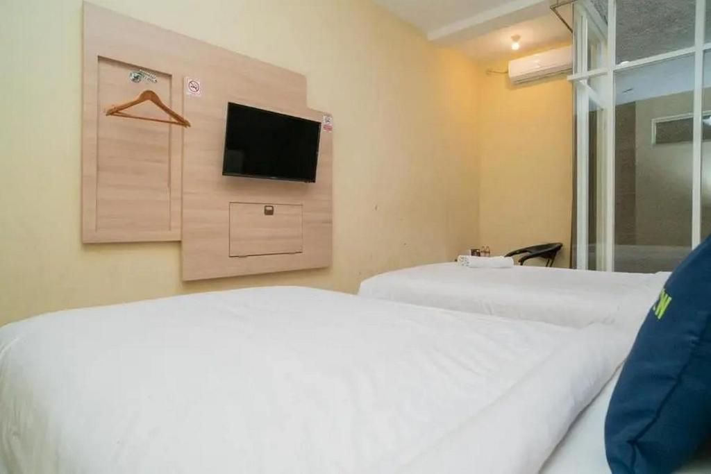 Postel nebo postele na pokoji v ubytování Urbanview Hotel Omah Anin Batu by RedDoorz