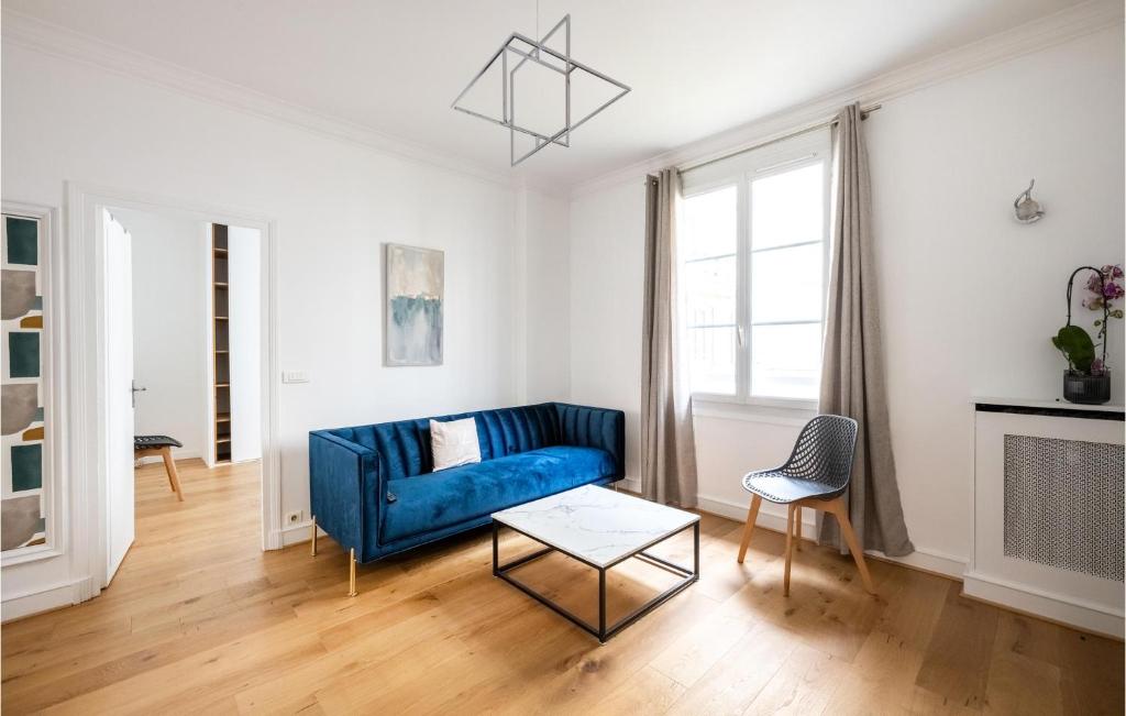 un soggiorno con divano blu e tavolo di 2 Bedroom Awesome Apartment In Colombes a Colombes