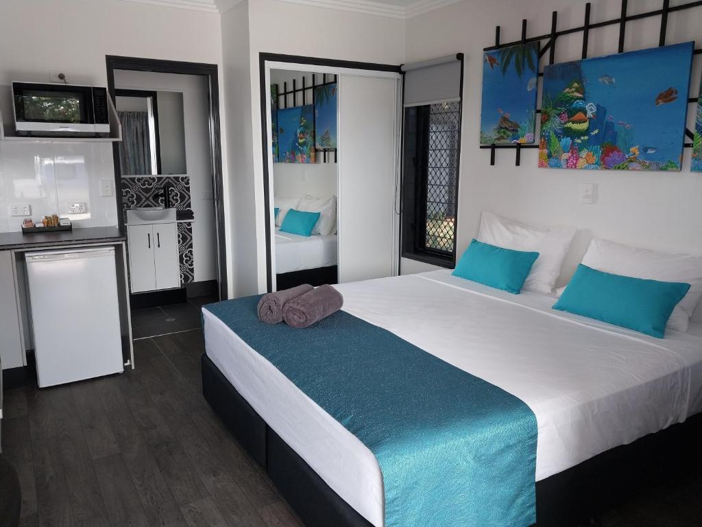 a bedroom with a large white bed with blue pillows at The Dugongs' Rest in Horn