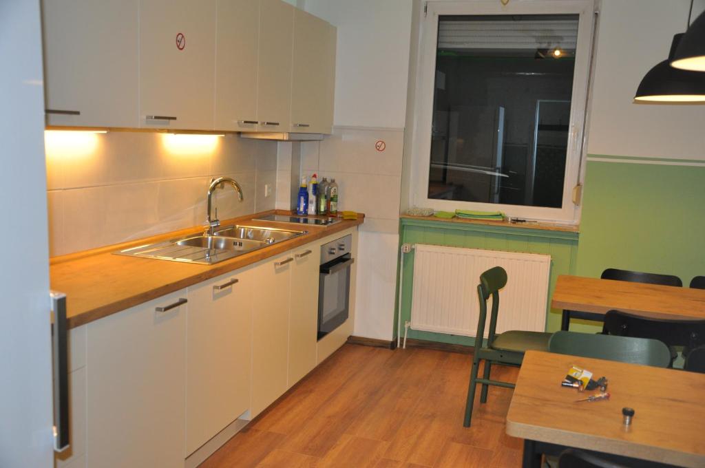 a kitchen with a sink and a counter and a table at Hostel KarMa in Gelsenkirchen