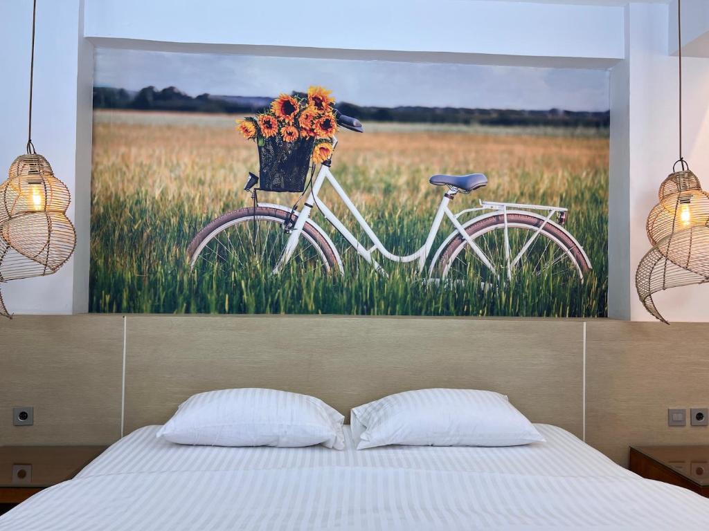 une peinture d'un vélo avec un panier de fleurs dans l'établissement Fastrooms Bekasi, à Bekasi