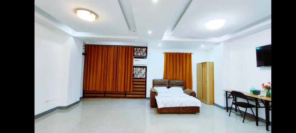 um quarto com uma cama, uma secretária e uma mesa em Masterpiece Staycation Makati em Manila
