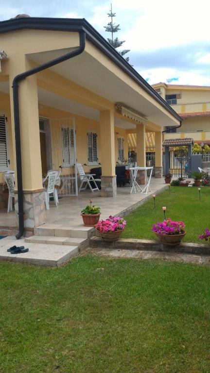 a house with two pots of flowers in the yard at Casa vacanza Sibari in Botricello