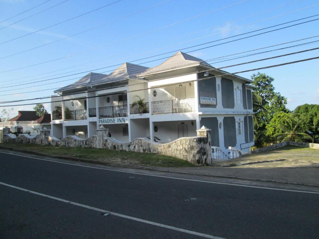 a white house on the side of a street at Paradise Inn in Port Antonio