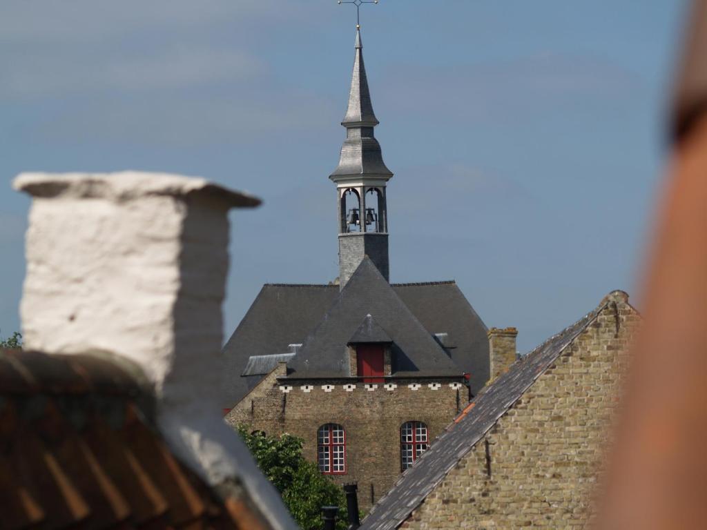 a church with a steeple on top of a building at Guesthouse Vlamynckpoort in Bruges