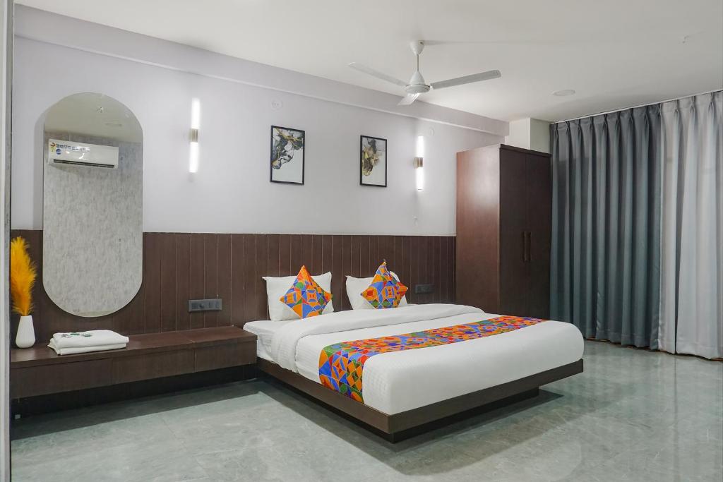 a bedroom with a large bed and a mirror at FabHotel Prime Stay Inn in Pune
