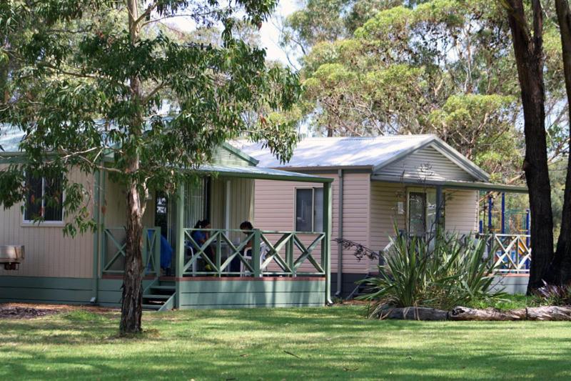 a house with a porch and a person standing on the porch at Mt Barker Holiday Park - Western Australia in Mount Barker