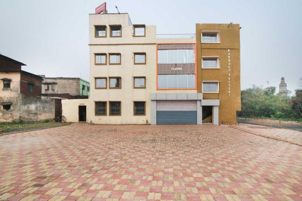 een gebouw met een bakstenen binnenplaats ervoor bij OYO Hotel Yamuna Banquet & Resort in Dhanbad