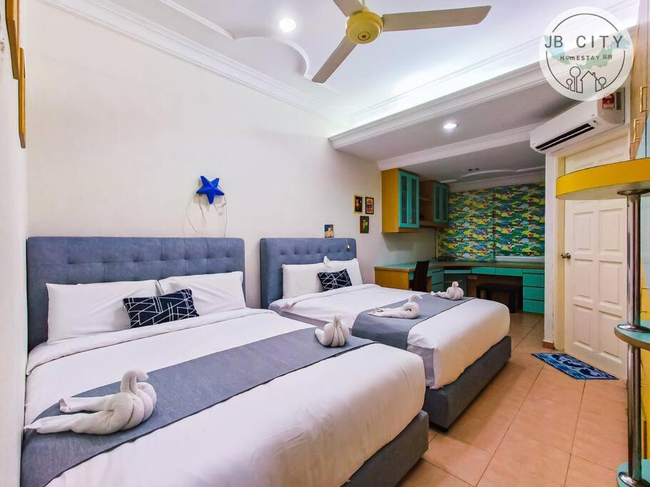 1 dormitorio con 2 camas con animales de peluche en Pelangi homestay by JBcity Home, en Johor Bahru