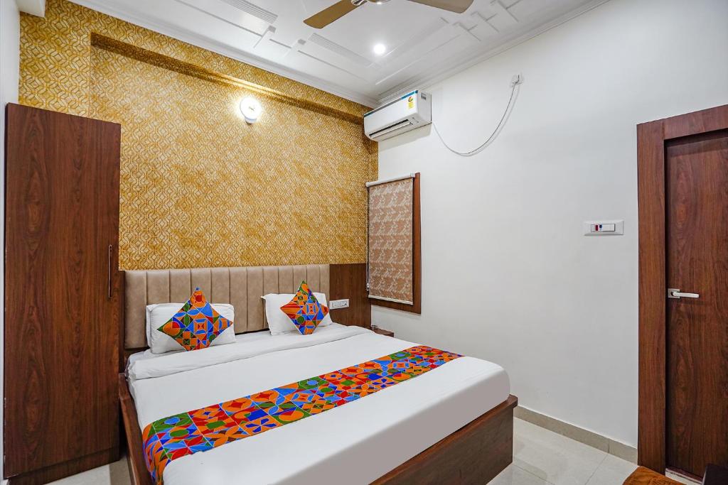 瓦拉納西的住宿－FabHotel Siddhant，一间卧室配有一张带彩色毯子的床
