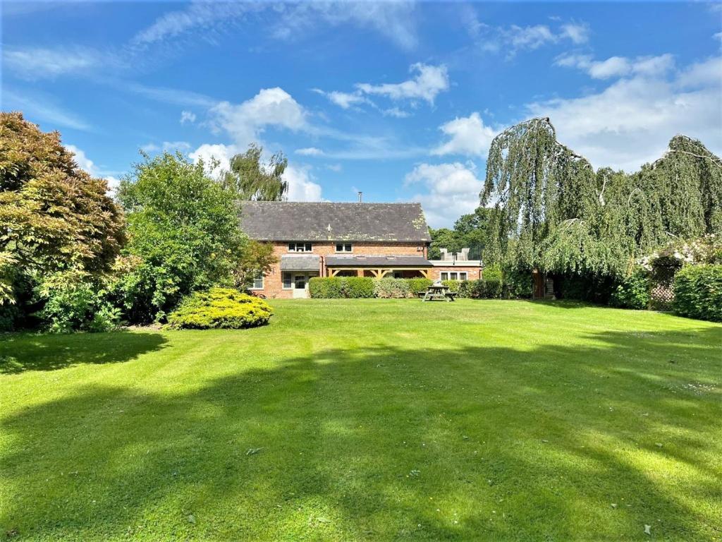 a large grassy yard with a house in the background at 3 Bed in Presteigne 78350 in Kinsham