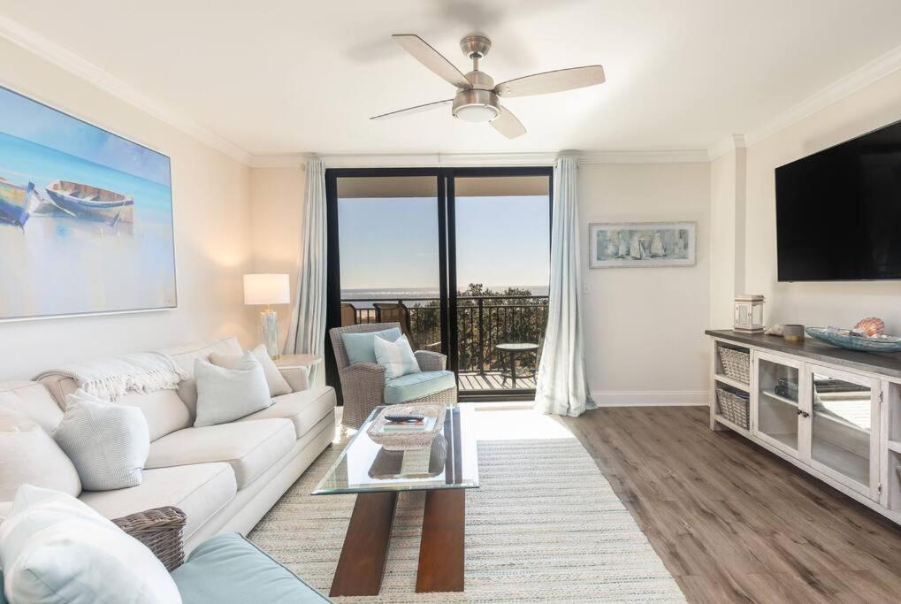 een woonkamer met een witte bank en een flatscreen-tv bij Shipwatch 418 - Luxury Oceanfront Penthouse in Isle of Palms in Isle of Palms