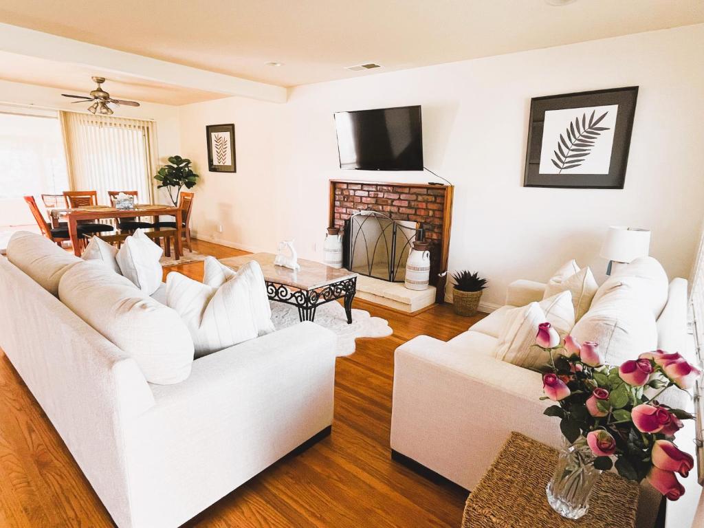 a living room with white couches and a fireplace at Saikwan Valley Family Home in Milpitas