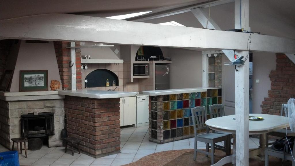 cocina con chimenea de ladrillo, mesa y barra en Flat in Central Poznan, en Poznan