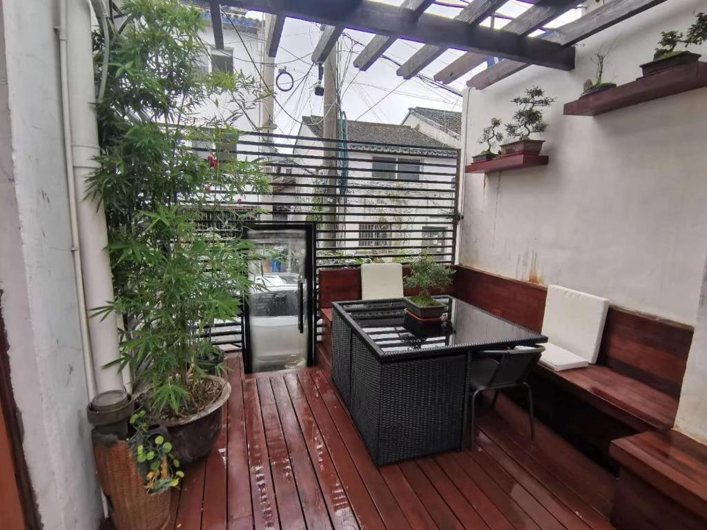 a patio with a table and chairs on a deck at 枕窗听雨客栈 in Suzhou