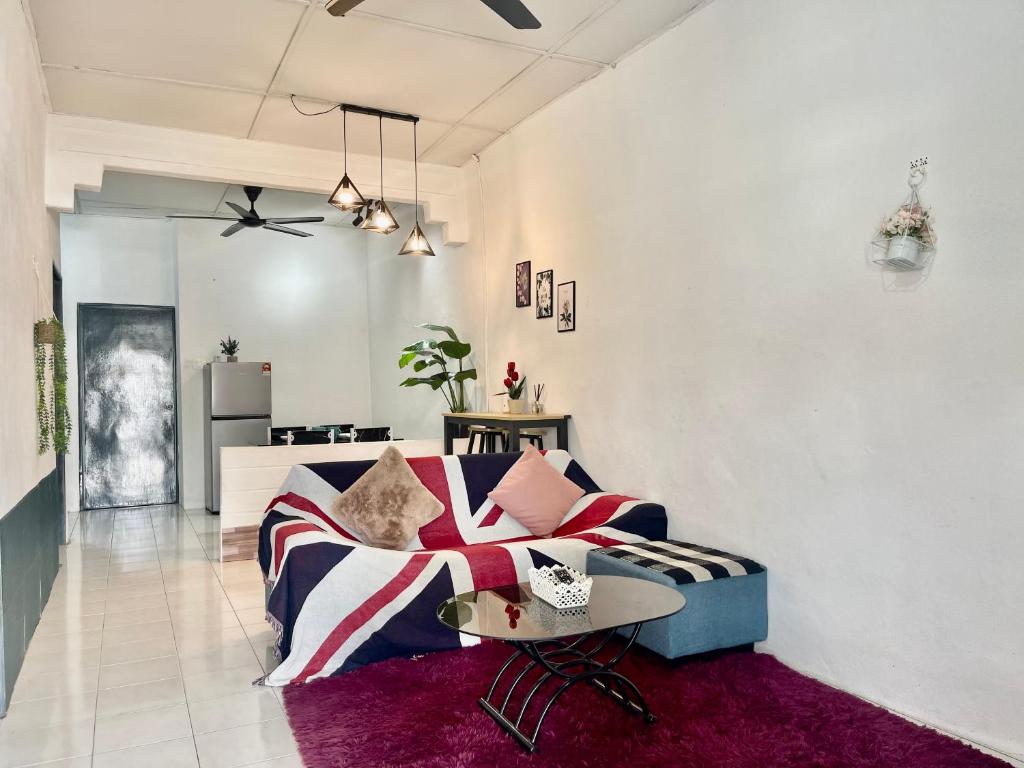 uma sala de estar com um sofá e uma mesa em Entire Cozy Home 16 • 3 bedroom @ Alma Bukit Mertajam em Bukit Mertajam