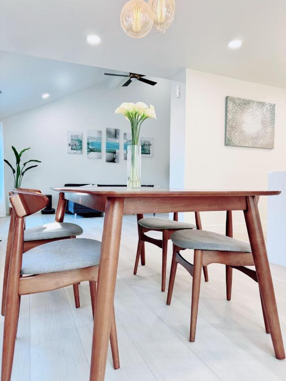 a dining room table and chairs with a vase of flowers at Trendy Trenholm in Elk Grove