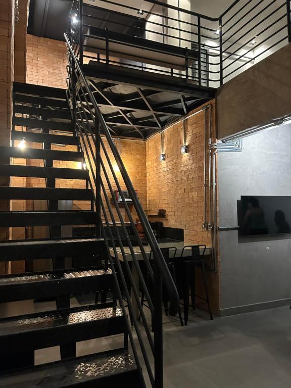 a spiral staircase in a room with a table at Pinheiros Duplex no pool in Sao Paulo