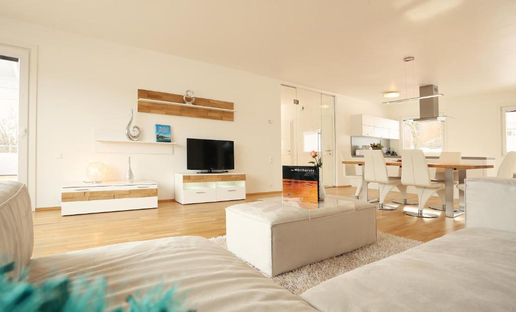 ein Wohnzimmer mit einem Sofa und einem Esszimmer in der Unterkunft Seevillen Excelsior in Velden am Wörthersee