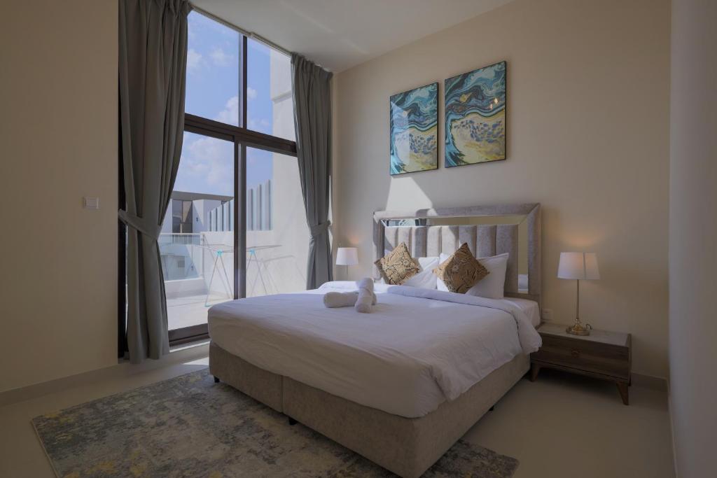 a bedroom with a large bed and a large window at Fabulous 4br villa with Balcony in Dubai