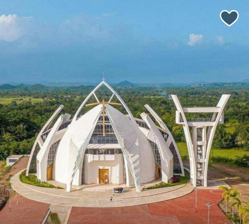 um grande edifício branco com um telhado em forma de coração em Casa grande lujosa em Bayaguana