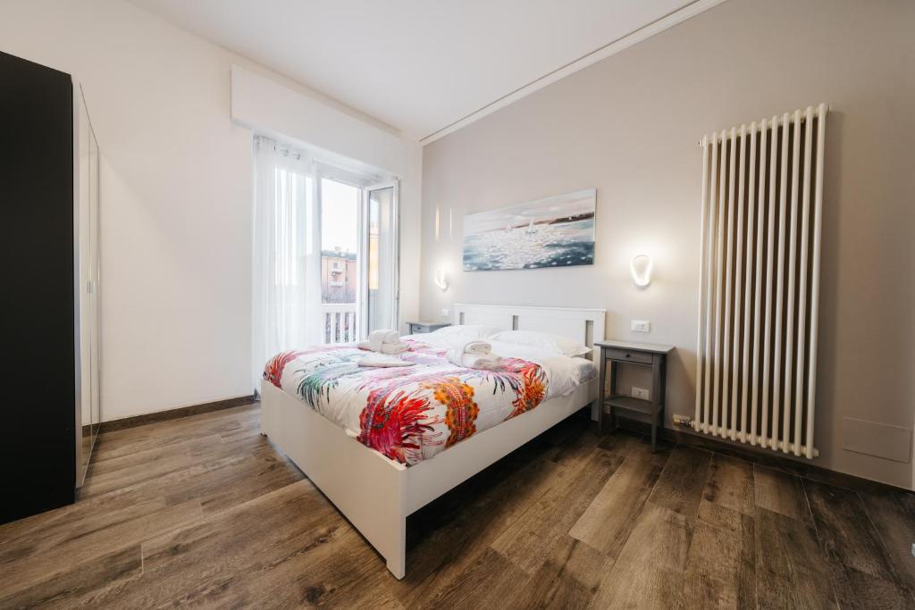 ein weißes Schlafzimmer mit einem Bett und einem Fenster in der Unterkunft Porta Nuova Suites in Verona