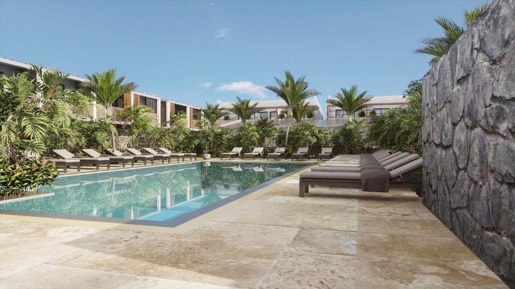 una piscina con sedie a sdraio e un resort di Dimitile Hôtel & Spa a Entre-Deux