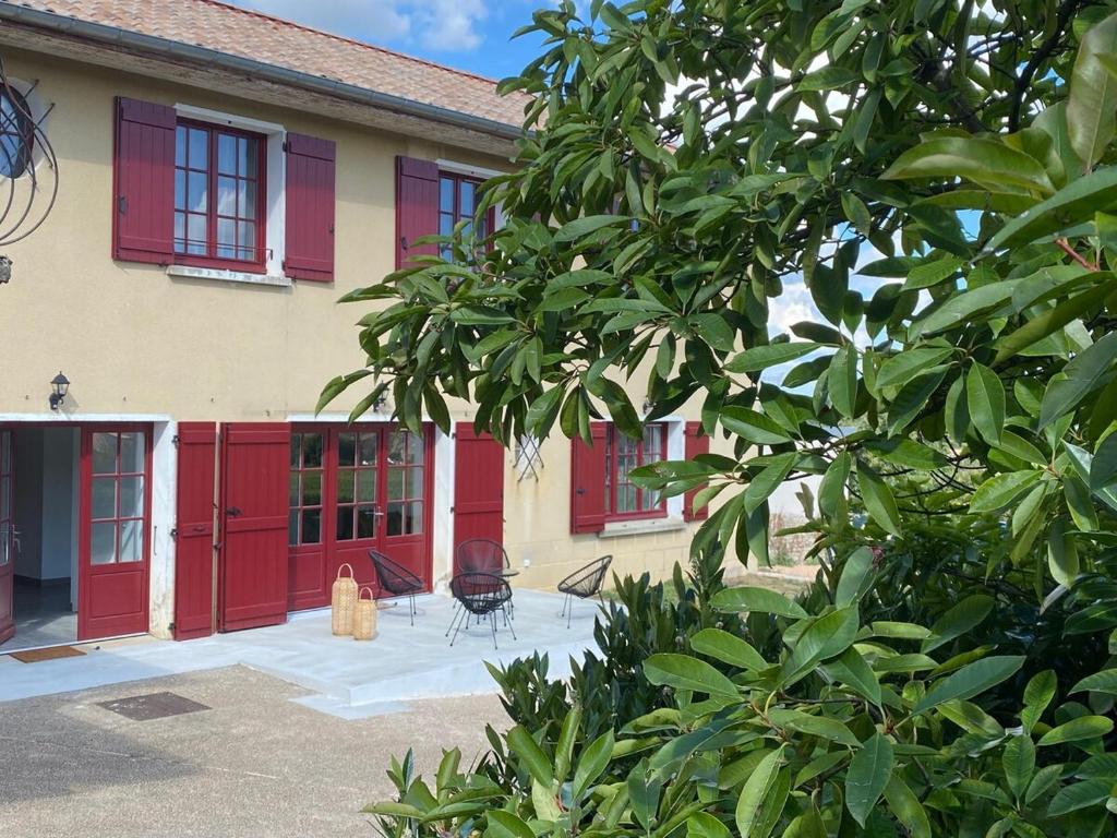 ein Haus mit roten Türen und einer Terrasse in der Unterkunft Black And White Swallow Fuiss in Fuissé